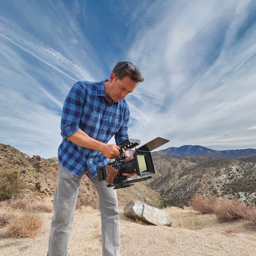 Dustin Sheffield holding a cinema camera in the desert